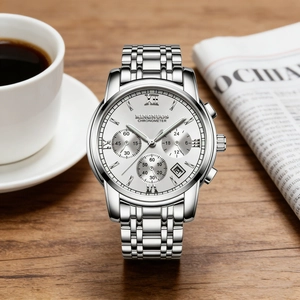 Detailed shot of a silver men's stainless steel watch with a luminous dial and date