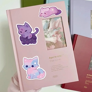 Detailed view of cute galaxy cat stickers applied on a pink notebook cover for decoration