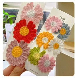 Close-up of handmade crochet flower hair clips in various bright knitted colors