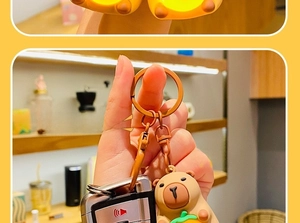 Close-up of cute Capybara keychain with orange on head and functional LED light feature