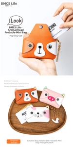 Nahaufnahme von Mini-Lederbeuteln mit Tierkopf-Design für Karten und Kopfhörer