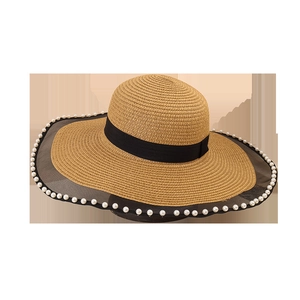 Women's woven straw sun hat with wide brim, pearl trim, and black mesh lace detail
