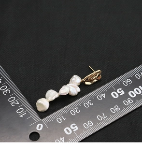 Detailed view of baroque pearl tassel earrings with ruler showing 50mm length dimension