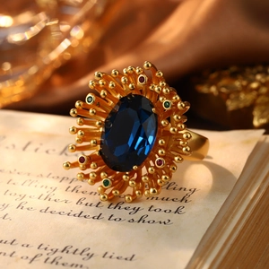 Macro shot of vintage style gold ring featuring an oval blue stone with sunburst detail
