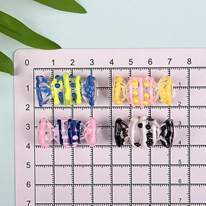Macro view of 2.5cm colorful candy-shaped glass beads with stripes and dots for DIY crafts