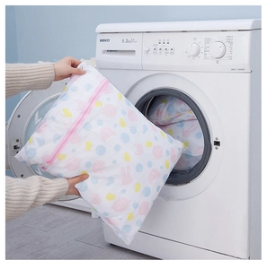 Placing a rabbit print mesh laundry bag into a white washing machine for clothing care