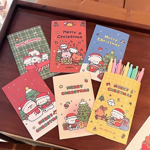 Close-up of colorful Christmas themed greeting cards and envelopes with matching pens