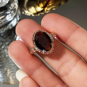 Macro shot of vintage rose gold ring with oval brown zircon and intricate filigree details