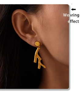 Detail shot of a model wearing a gold tree branch earring in PVD plated stainless steel