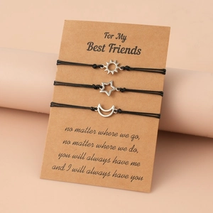 Three adjustable friendship bracelets with sun, moon and star pendants on kraft card