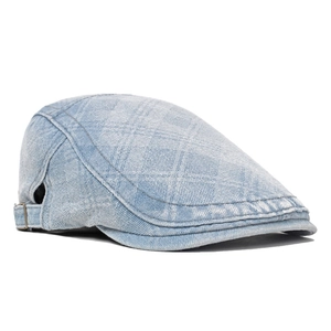 Detail of light blue denim flat cap featuring subtle plaid texture and metal side buckle