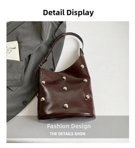Detail view of burgundy glossy shoulder bag with vintage silver metallic stud ornaments