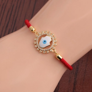 Gros plan d'un pendentif Main de Hamsa et Oeil Mauvais sur un bracelet en cordon rouge au poignet