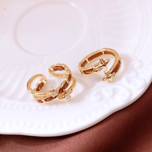 Detail of gold star rings with leather inlay displayed on a vintage ceramic plate