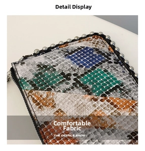 Detail showing multi-color snakeskin texture and silver metal rivets on the handbag
