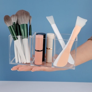 Close-up of a 3-slot acrylic makeup brush holder showing storage of lipsticks and tools