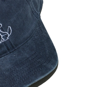 Detailed macro view of navy blue washed cotton baseball cap with white Snoopy embroidery