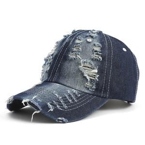 Distressed dark blue denim baseball cap with vintage ripped details and frayed edges