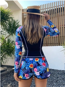 Rear view of two-piece long sleeve swimsuit with tropical floral prints in resort setting