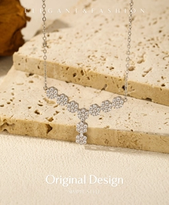 Macro shot of silver Y-shaped necklace with flower clusters and sparkling zircon stones