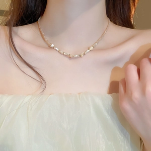 Detail of irregular shell and crystal beads on a chic beige and white necklace