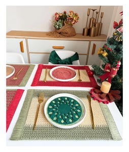 Detail of red and green woven paper placemats with festive Christmas holiday table decor