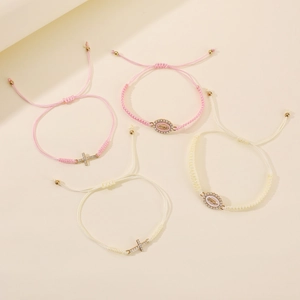 Detail of handmade woven cross and virgin mary bracelets with sparkling rhinestone accents