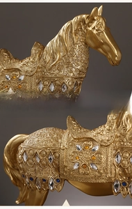 Macro detail of golden resin horse statue with intricate carvings and colorful gemstones