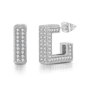 Macro detail of silver geometric hoop earrings with paved cubic zirconia stones