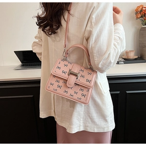 Elegante borsa rosa con stampe di fiocchi neri, fibbia metallica e dettaglio del manico