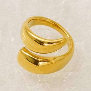 Macro detail of gold-plated geometric wrap ring with polished mirror finish and open band