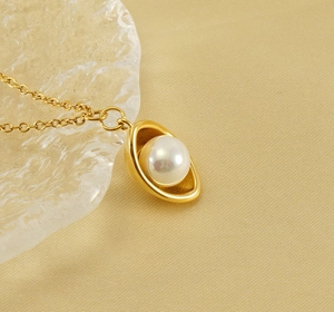 Detail of 18k gold-plated ingot pendant with pearl on luxury silk background