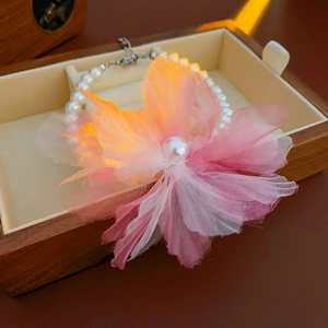 Close-up of pearl necklace with a gradient mesh flower in a wooden jewelry box