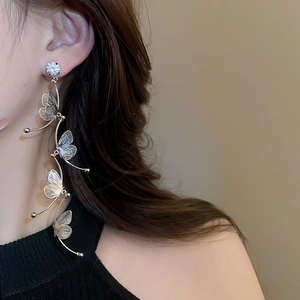 Close-up of model wearing silver long tassel butterfly earrings with sparkling crystals