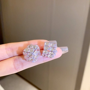 Detailed close-up of cubic zirconia geometric cluster stud earrings in silver finish