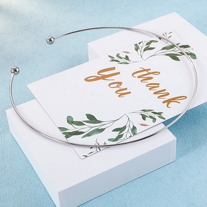 Polished silver C-shaped titanium steel collar necklace with spherical ends on gift box