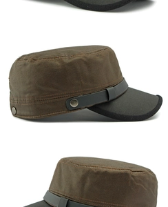 Detail view of brown waxed canvas military cap with leather strap and metal buckle