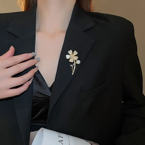 Gros plan détaillé d'une broche florale avec nacre et zircons brillants sur un veston