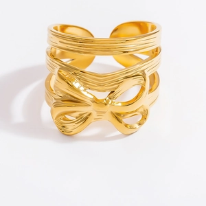 Macro view of gold bow-shaped stainless steel ring detail with metallic luster