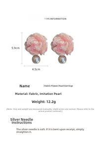 Detail view of pink fabric flower earrings with grey pearls and silver needle specs