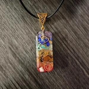 Detail of Orgone energy pendant with colorful natural stones and copper wire spiral