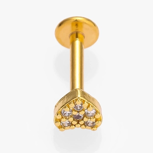 Detail of a gold heart-shaped piercing stud with sparkling zircon stones on a white background