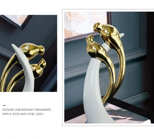 Dettaglio di lussuosi uccellini ornamentali in ceramica bianca e oro stile moderno