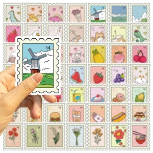 Hand holding a fresh cartoon windmill stamp sticker with colorful fruit and animal patterns