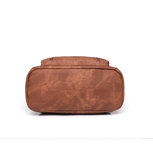 Close-up of bottom stitching and brown leather texture on a vintage PU backpack