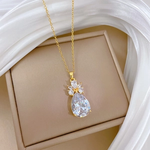 Collier en acier titane doré avec pendentif cristal en forme de poire sur soie