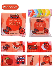 Detail view of red-themed soft baby cloth book featuring fire truck and apple patterns