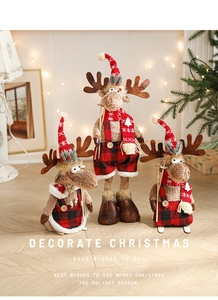 Close-up of three plush Christmas reindeer figurines with red plaid outfits and ski bases