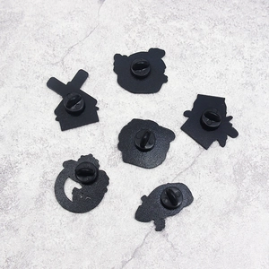 Detail view of the black metal badge backings with rubber butterfly clutch pins