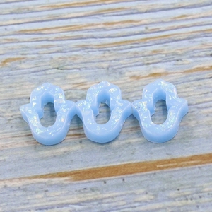 Detailed view of three blue Hamsa hand resin pendants with sparkling opal finish